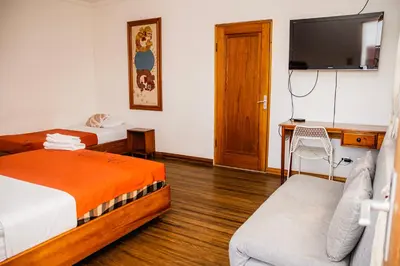 a hotel room with two beds and a flat screen tv at Hotel Luz de Luna in San José