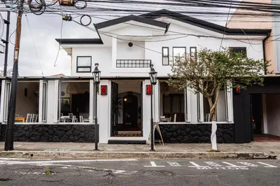 a white building on the corner of a street at Hotel Luz de Luna in San José