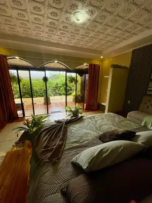 a bedroom with a large bed and a large window at Ara Ambigua Lodge in Sarapiquí