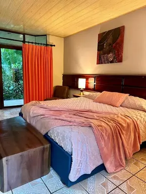 a bedroom with a large bed and a window at Ara Ambigua Lodge in Sarapiquí