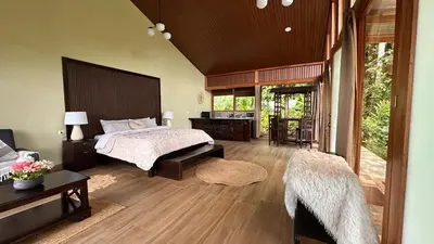 a bedroom with a bed and a desk and a table at Ara Ambigua Lodge in Sarapiquí
