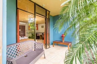 a porch with a bench and a table at Ara Ambigua Lodge in Sarapiquí