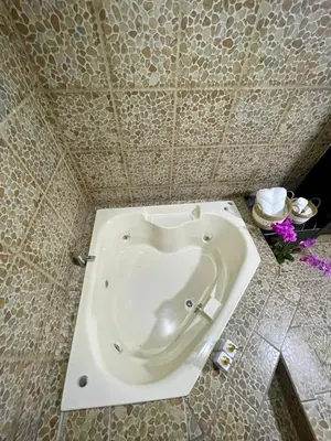 a white tub in a bathroom with a tiled wall at Ara Ambigua Lodge in Sarapiquí