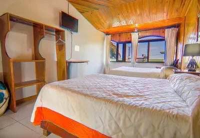 a bedroom with two beds and a large window at Hotel Don Taco in Monteverde Costa Rica