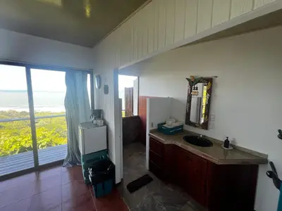 a bathroom with a sink and a mirror and a window at Ranchos Remo Lodge in Uvita