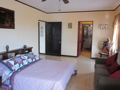 a bedroom with a bed and a couch at Villa Alta Bed&Breakfast in Barranca