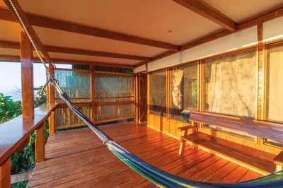 a room with a hammock on a porch at Punta Marenco Lodge in Drake