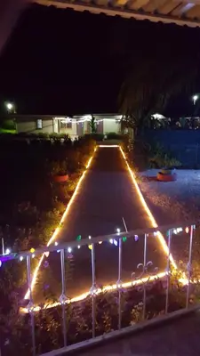 a driveway lit up with christmas lights at night at Hotel La Arena in Liberia