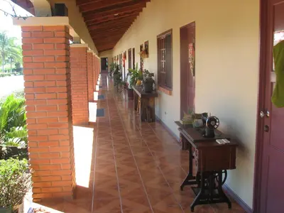 a hallway of a house with a brick floor and desks at Hotel La Arena in Liberia