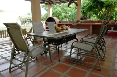 a table with chairs and a bowl of fruit on a patio at Hotel La Arena in Liberia