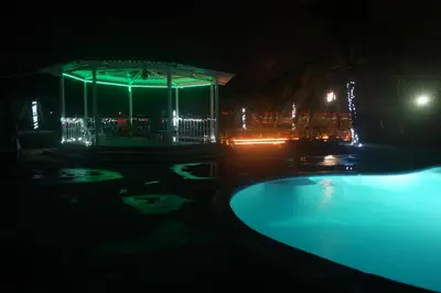 a swimming pool at night with a gazebo at Hotel La Arena in Liberia
