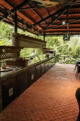 a patio with a bar and a person preparing food at Tapirus Lodge and Reserve in Carrillo