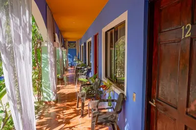 a building with blue walls and chairs on a porch at Conchal Hotel in Brasilito