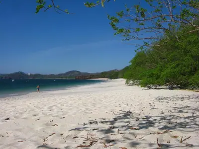 a person standing on a beach near the water at Conchal Hotel in Brasilito