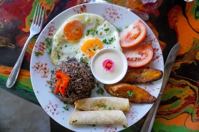 a plate of breakfast food with eggs and rice at Conchal Hotel in Brasilito
