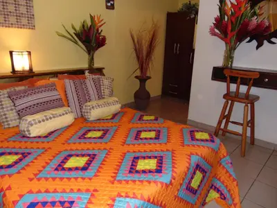 a bedroom with a bed with a colorful quilt on it at Casa Lima B&B in San José