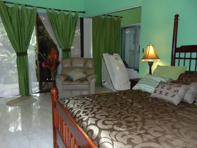 a bedroom with a large bed and a chair at Casa Lima B&B in San José