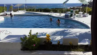 a swimming pool with two people in the water at Barracuda apartments in Sámara