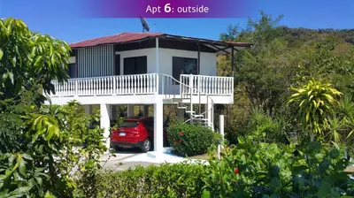 a house with a red car parked in front of it at Barracuda apartments in Sámara