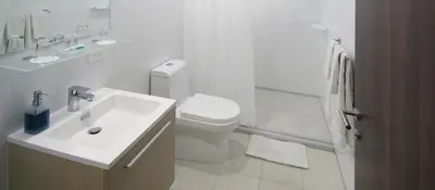 a white bathroom with a sink and a toilet at Isla Verde Hotel in San José