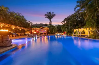 a large swimming pool in a resort at night at Leyenda Boutique Hotel & Spa in Sámara