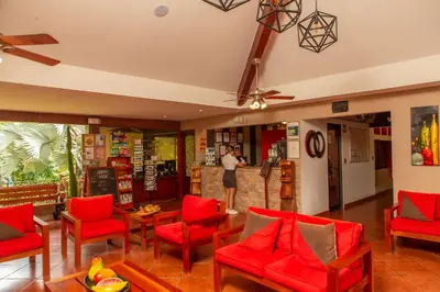 a lobby with red chairs and a bar at Leyenda Boutique Hotel & Spa in Sámara
