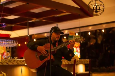 a man playing a guitar in a bar at Leyenda Boutique Hotel & Spa in Sámara