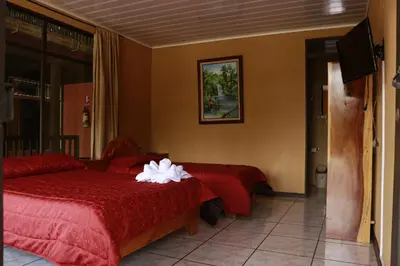 a hotel room with two beds and a television at Cabinas Eddy B&B in Monteverde Costa Rica