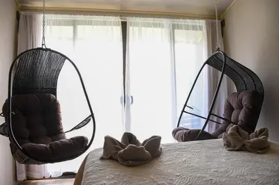 a bedroom with two hanging chairs and a bed at Cabinas Eddy B&B in Monteverde Costa Rica
