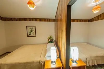 two twin beds in a room with two lamps at Cabinas Eddy B&B in Monteverde Costa Rica