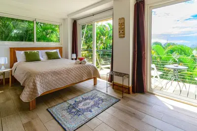 a bedroom with a bed and a large window at Funky Monkey Lodge in Santa Teresa Beach