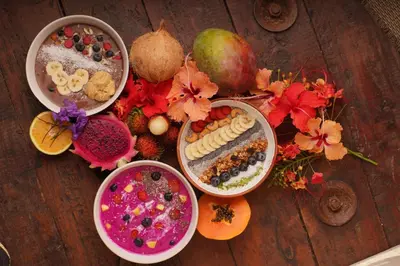 a group of bowls of food on a wooden table at Funky Monkey Lodge in Santa Teresa Beach