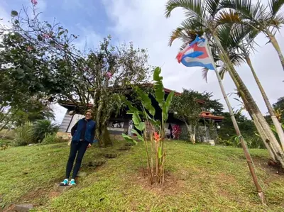 a person standing next to a flag in a yard at Navarro mountain in Cartago