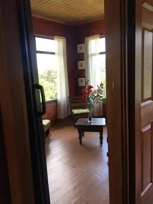 a room with a table with a vase of flowers on it at Navarro mountain in Cartago