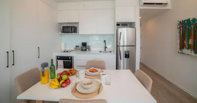 a white kitchen with a table with fruit on it at BEE Suites San José - Escalante in San José