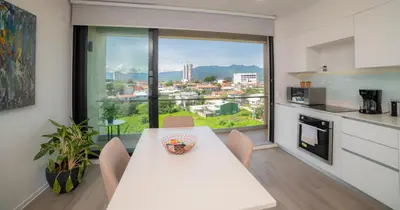 a kitchen with a white table and a large window at BEE Suites San José - Escalante in San José