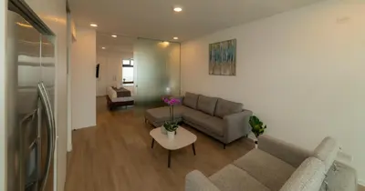 a living room with a couch and a table at BEE Suites San José - Escalante in San José
