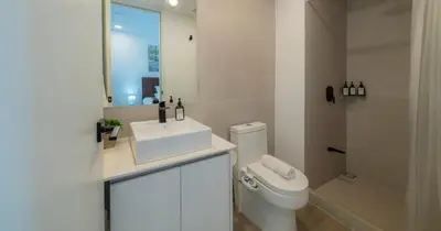 a bathroom with a sink and a toilet and a mirror at BEE Suites San José - Escalante in San José