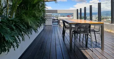 a wooden deck with a table and chairs on a balcony at BEE Suites San José - Escalante in San José
