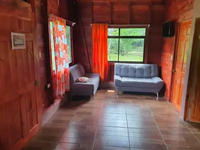 a living room with two chairs and a window at Into the Greens in Madre de Dios