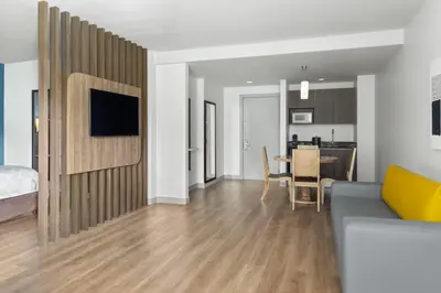 a living room with a couch and a dining room at Holiday Inn Express San Jose Forum by IHG in San José