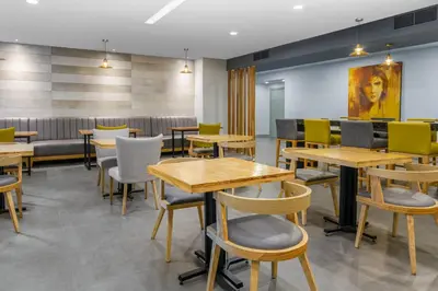 a restaurant with tables and chairs in a room at Holiday Inn Express San Jose Forum by IHG in San José