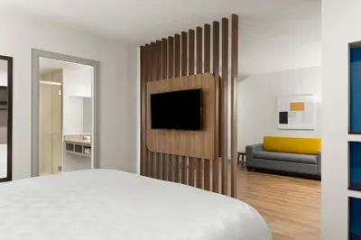 a bedroom with a bed and a tv and a couch at Holiday Inn Express San Jose Forum by IHG in San José