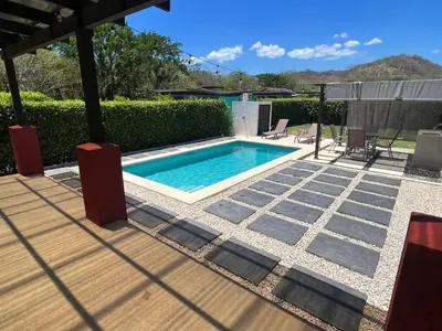 a swimming pool in a yard with a patio at Casa vacacional Tamarindo beach in Guatemala