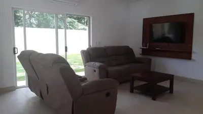 a living room with a couch and a chair and a television at Peaceful and beautiful Casa Almita Bonita in Sámara