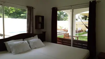 a bedroom with a bed and a large window at Peaceful and beautiful Casa Almita Bonita in Sámara