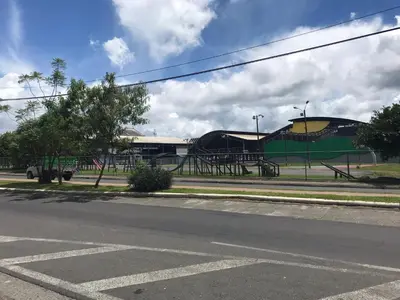 an empty street with a playground in front of a building at El mochilero in Cartago