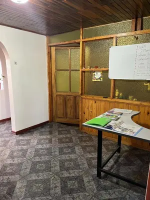 a classroom with a table and a whiteboard on the wall at El mochilero in Cartago