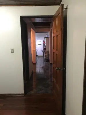 a hallway with an open door to a room at El mochilero in Cartago
