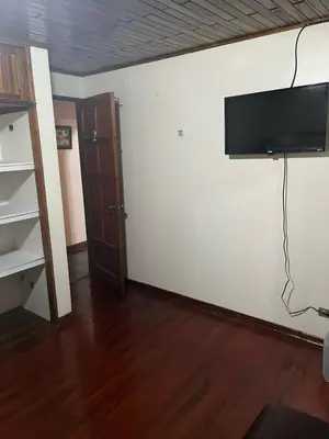 a living room with a flat screen tv on a wall at El mochilero in Cartago